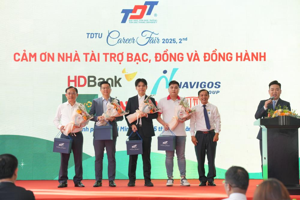 Thầy Tăng Khắc Quý – Giám đốc Trung tâm Hợp tác Doanh nghiệp và Cựu sinh viên tặng hoa và quà lưu niệm cho Nhà tài trợ Bạc, Đồng, Đồng hành và Đơn vị hỗ trợ truyền thông