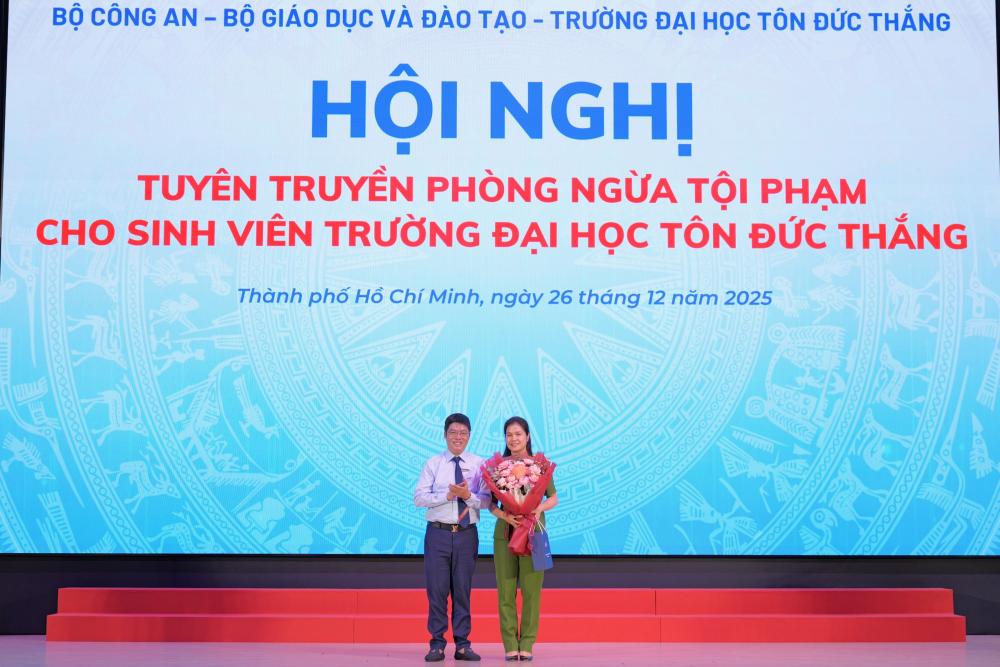 Đại diện lãnh đạo Nhà trường tặng hoa tri ân báo cáo viên trình bày chuyên đề tại Hội nghị