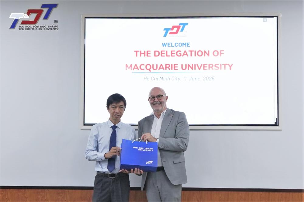 Representatives of both universities exchanging gifts and taking commemorative photos