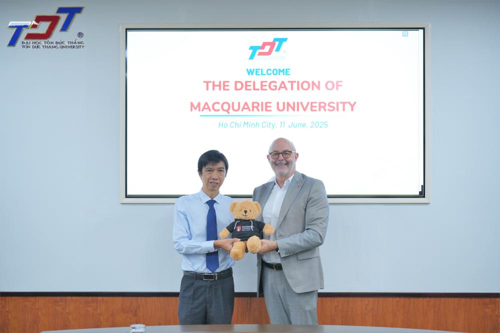 Representatives of both universities exchanging gifts and taking commemorative photos
