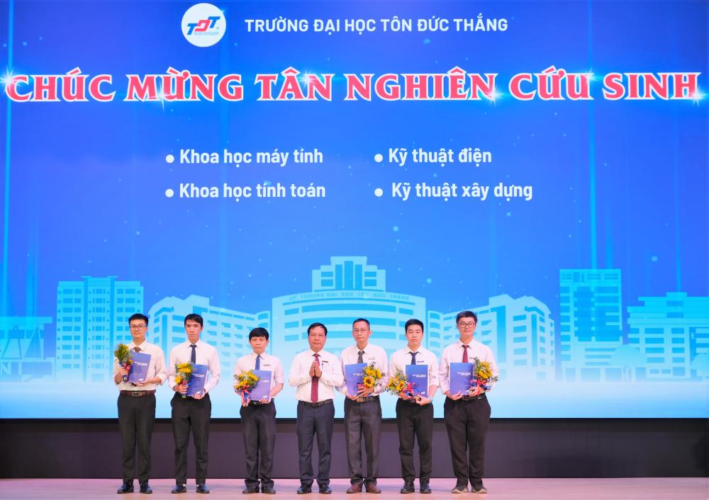 TS. Vũ Anh Đức – Bí thư Đảng ủy, Chủ tịch Hội đồng trường trao thư chúc mừng cho các tân nghiên cứu sinh tiến sĩ